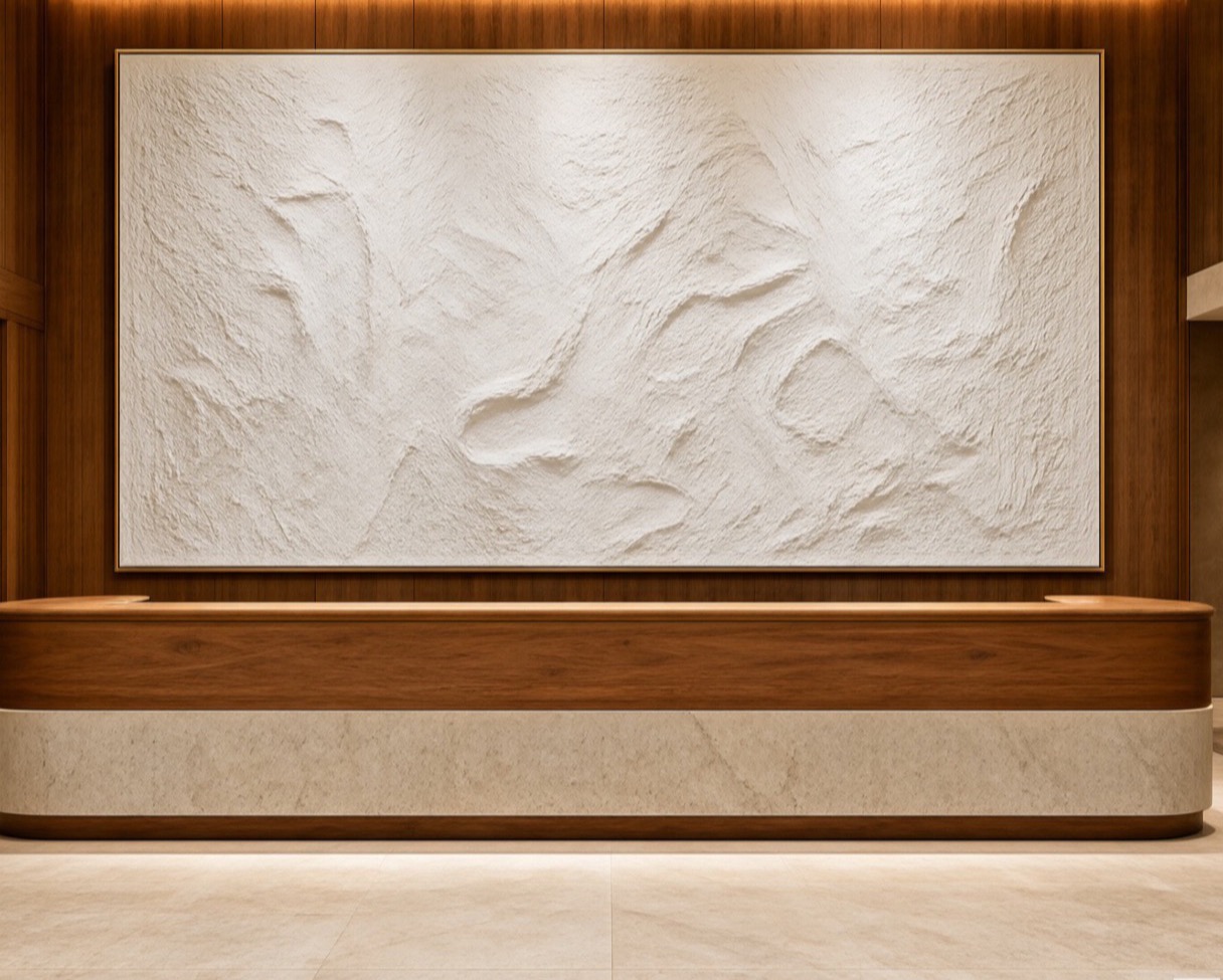 Boutique hotel lobby with an oversized textured painting behind the reception desk